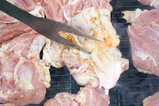 Raw pork chops on grill. Smoke rising from heated grill