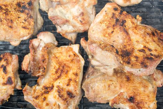 Closeup of grilled pork chops. Meat is still smoking on grill