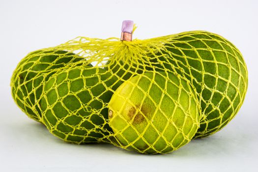 High resolution and quality photo of lemons inside yellow net.