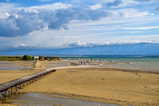 Wooden bridge leading to Famous Queens Beach in Nin near Zadar, Croatia. Rare sand beach in the Adriatic sea, due favorable wind the beach is popular for surfing and kitesurfing