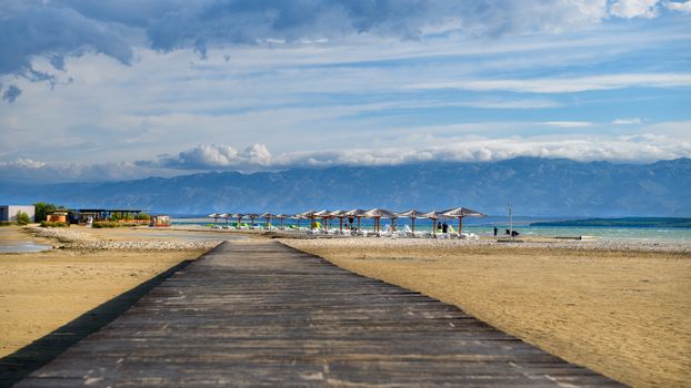 Wooden bridge leading to Famous Queens Beach in Nin near Zadar, Croatia. Rare sand beach in the Adriatic sea, due favorable wind the beach is popular for surfing and kitesurfing