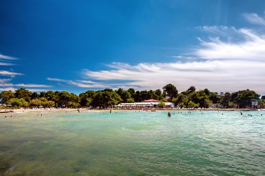 Luxury sand beach in Borik, Zadar Croatia, people sunbathing and swimming, luxury hotels in background righ next to the beach. District of Puntamika