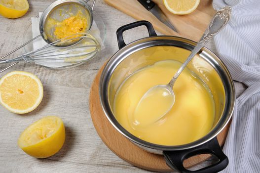 Freshly prepared lemon kurd - custard on fruit juice, in a saucepan stir with a spoon