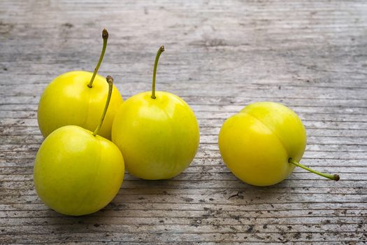 yellow Cherry plum (Prunus cerasifera). ripe of fruit on woody table