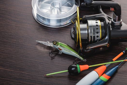 Coil and floats for a fishing rod on a wooden background