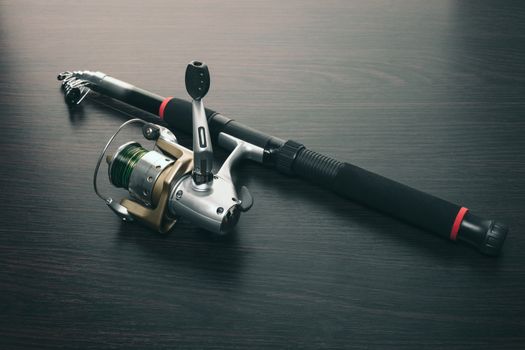fishing rod with a coil on wooden background