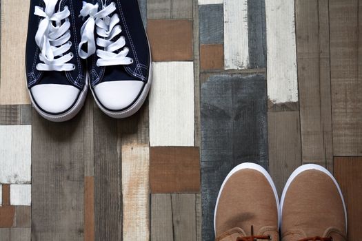 Two pair of shoes on color wooden background with free space