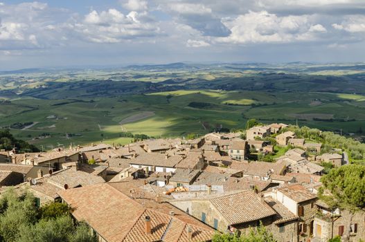 Rooftops of Montalcino and scenic view of typical Tuscany landscape in Val D'Orcia: hills, meadows and green fields. Tuscany, Italy, Europe