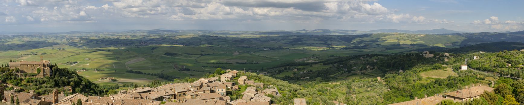 Rooftops of Montalcino and scenic view of typical Tuscany landscape in Val D'Orcia: hills, meadows and green fields. Tuscany, Italy, Europe