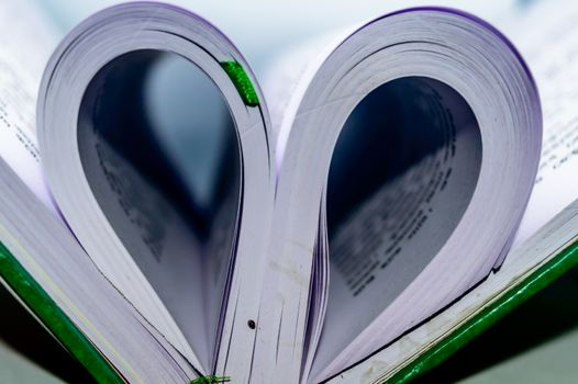 Close up heart shape from paper book with blur background. Heart book page - vintage effect style pictures. Concept for valentine's day.