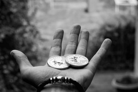 Europe leaving. Two big brexit coins with british map on man hand. Black and white concept.