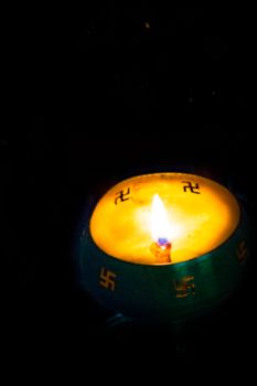 Flame of oil lamp on dark background, a burning oil lamp in darkness, with copy space. concept of removing darkness with a flame, are common in india and nepal for festival usage.