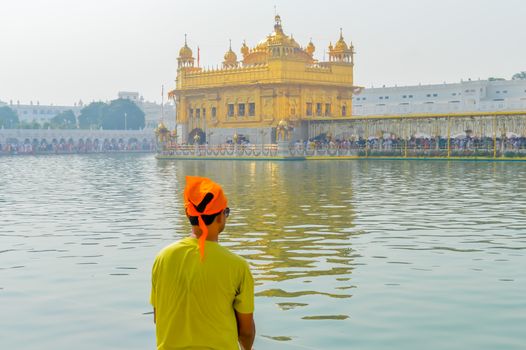 Sikh pilgrim praying in holy tank near Golden Temple (Sri Harmandir Sahib), Amritsar, INDIA. Captured in Sunny summer day, during festival time.