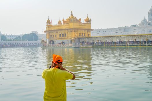 Sikh pilgrim praying in holy tank near Golden Temple (Sri Harmandir Sahib), Amritsar, INDIA. Captured in Sunny summer day, during festival time.