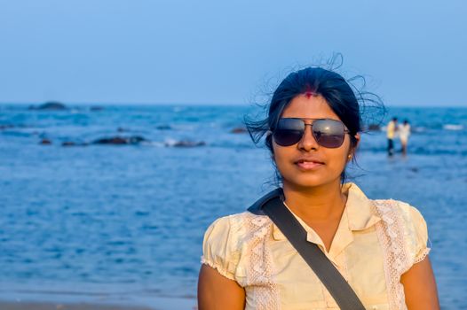 Beauty portrait of female face with natural skin. Young beautiful woman poses on the beach background.