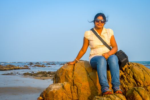 Cute woman relaxing on the tropical beach, outside tropical resort, Vacation concept. Goa India