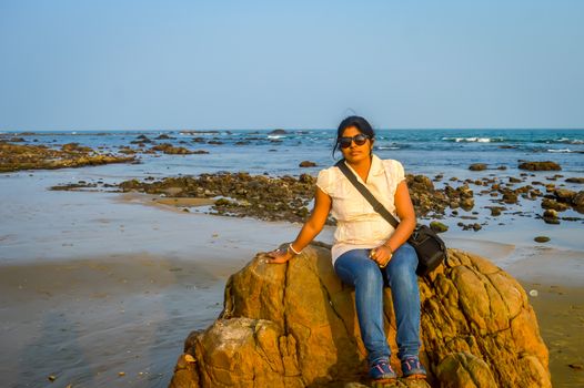 Cute woman relaxing on the tropical beach, outside tropical resort, Vacation concept. Goa India