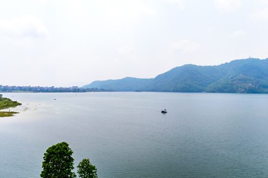 Photograph of autumn colourful lake mountain with clear sky. Wide angle landscape of Pokhara Lake at Kathmandu Nepal. Vintage film look. Vacation Freedom, Simplicity Concept.