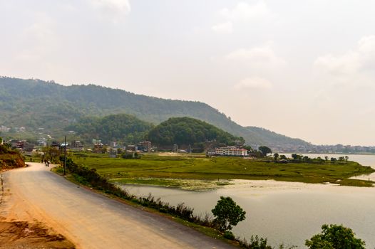 Photograph of empty road with hill in surrounding near Pokhara Lake at Kathmandu Nepal. Snap in portrait, landscape, wide screen style. Vintage film look. Vacation Freedom, Simplicity Concept.