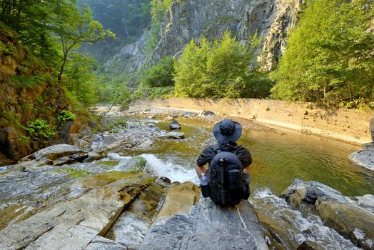young man with  backpack enjoying  on  mountain and waterfall