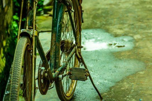 Old rusty vintage bicycle parked near road on a rural nature close up.