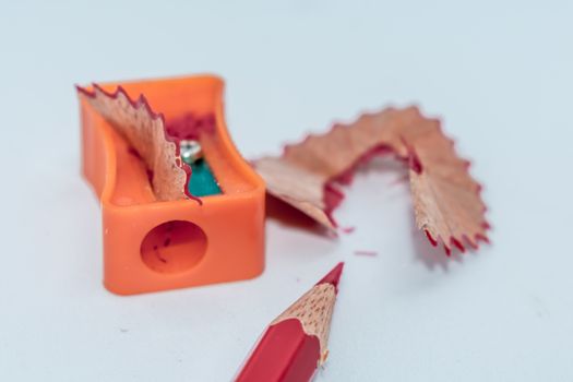 Selective Focus: Color pencil with sharpener shavings on white background