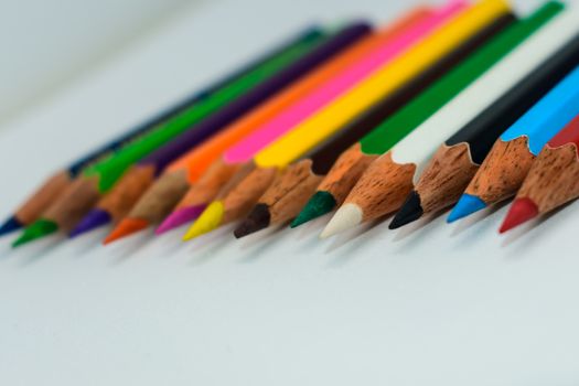 Selective Focus. Colored pencil set loosely arranged - on white background.