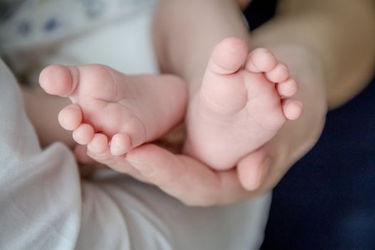 Small baby feet cupped into mothers hands