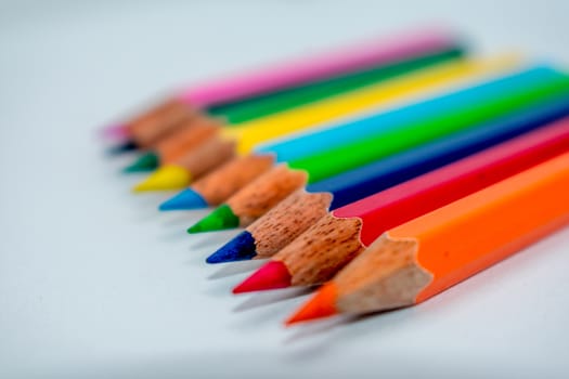 Pencils lined up in shallow focus. Color pencils isolated on white background for drawing with copy space.