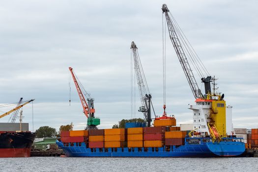 Blue container ship loading in cargo port of Europe