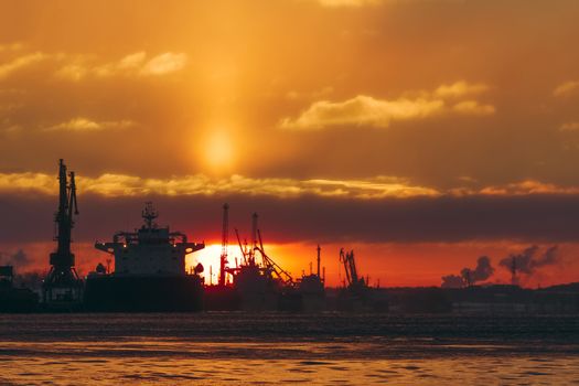 Colorful winter sunrise against the cargo port