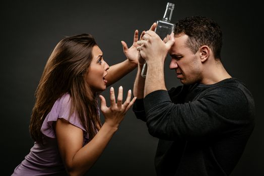 Angry aggressive drunk husband is physically abusing his wife. 