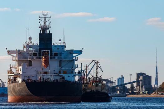 Black cargo ship entering the port of Riga, Europe