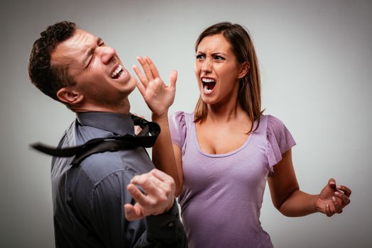 Angry aggressive wife trying to hit her husband.