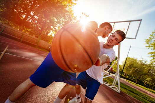 Two street basketball players playing one on one. They are making a good action and guarding the ball.