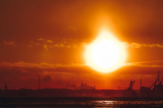 Hot orange winter sunrise against the cargo port