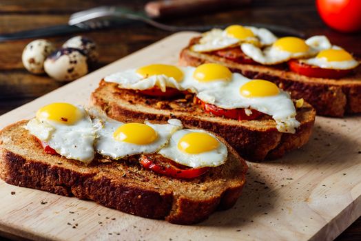 Toasts with Fried Quail Eggs on Cutting Board