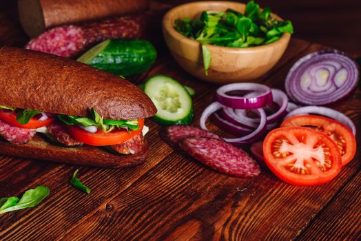 Sandwich with Salami and Vegetables. Sliced ingredients.