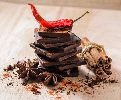 Condiment Still Life. Cayenne Pepper with Anise Star, Cinnamon and Chocolate Bar Stack.