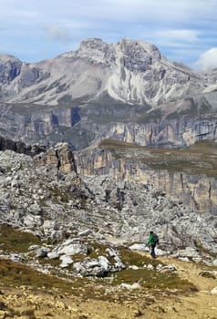 Hiker walking on a path in Dolomites, Italy