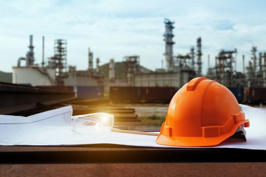 Helmet construction and safety glasses on the blueprint with industrial background.