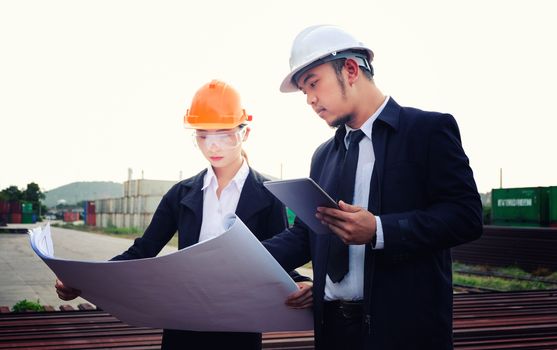 The engineer is checking a layout on large industry background. The construction manager on the industry background.