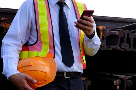 The engineer is working with smart phone on large industry background. The construction manager on the industry background.