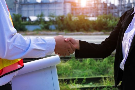 The engineer guy is shaking hands with construction manager. Dealing the contract.