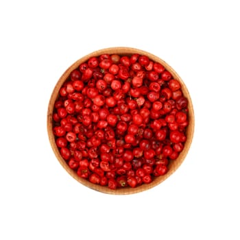 Close up one wooden bowl full of red pink pepper peppercorns isolated on white background, elevated top view, directly above