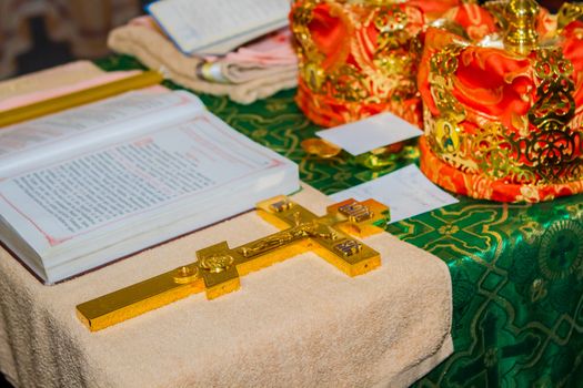 Church utensil, wedding crowns on an altar, cross and the Bible on table ceremony