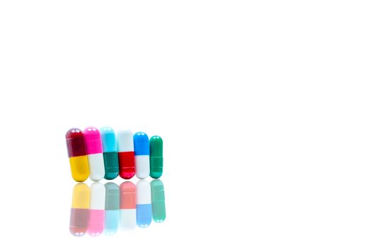 Antibiotic capsules pills in a row on white background with shadows and copy space. Drug resistance concept. Antibiotics drug use with reasonable and global healthcare concept. Pharmaceutical industry. Pharmacy background. Health budgets and policy.