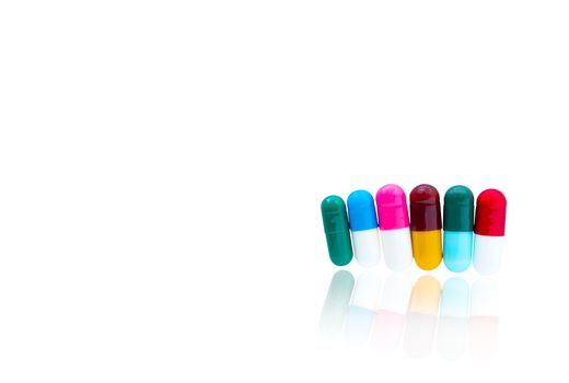 Antibiotic capsules pills in a row on white background with shadows and copy space. Drug resistance concept. Antibiotics drug use with reasonable and global healthcare concept. Pharmaceutical industry. Pharmacy background. Health budgets and policy.