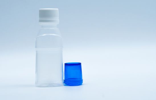 Sterile eye lotion in white plastic bottle with blue eyebath and copy space and blank label. Eye wash after contact pollution environment or after swimming in chlorine contaminate pool.