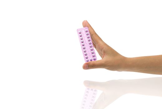 Asian young woman holding pack of contraceptive pills with one hand isolated on white background with copy space and clipping path. Choosing family planning with birth control pill concept.